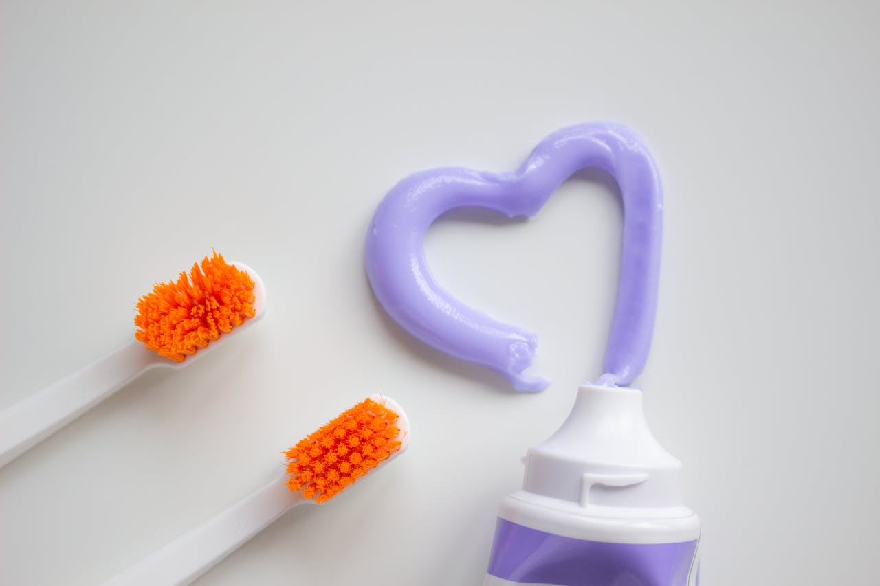 Bright image of toothbrushes and heart-shaped toothpaste promoting dental hygiene.